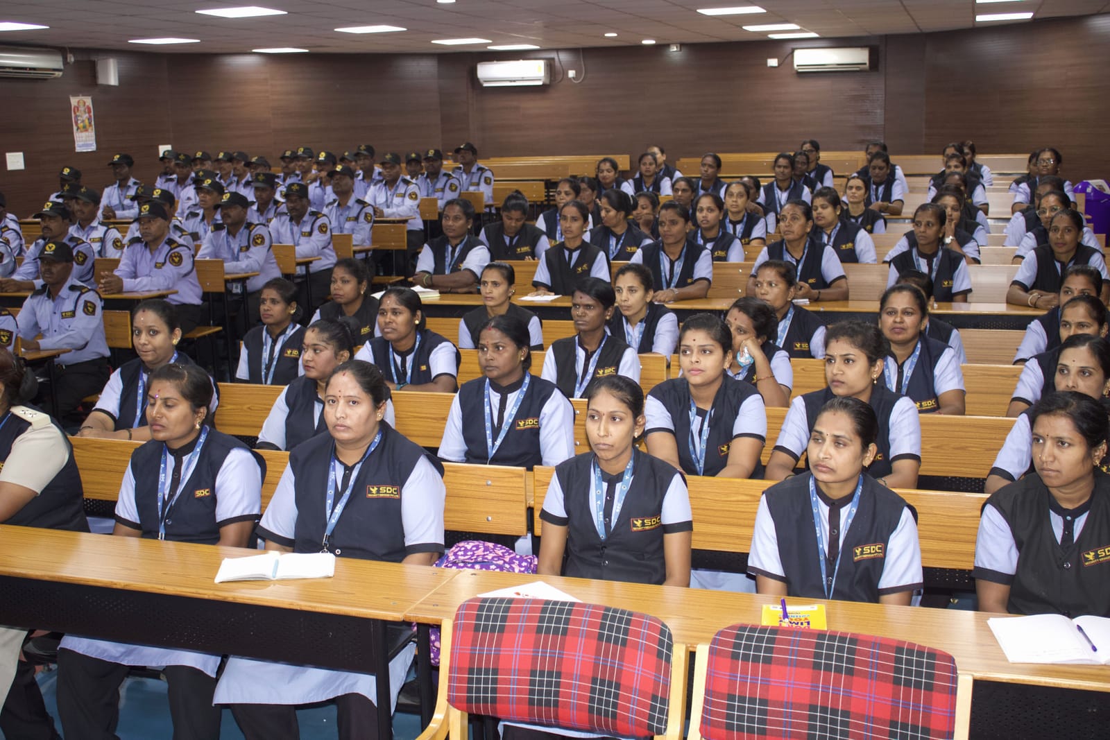 Rows of SDC lady guards and guards taking notes in a lecture hall