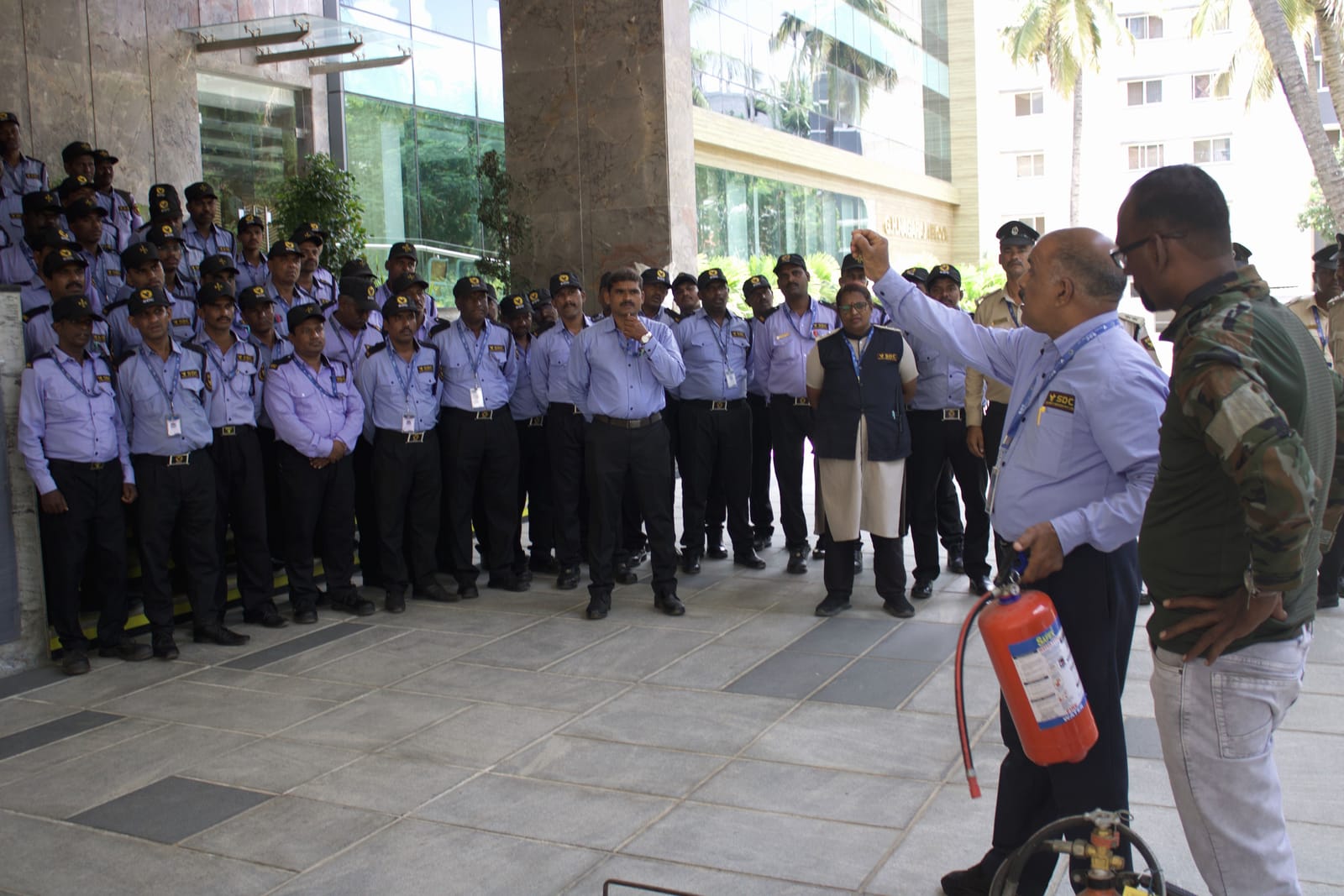 An instructor briefing a formation of SDC guards with a fire extinguisher before a drill